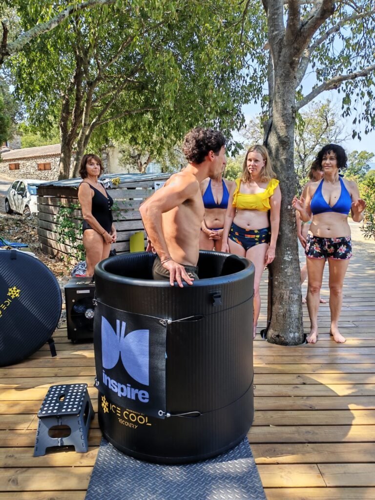 Un participant dans un bain froid Une Vie de Conscience, entouré du groupe du week-end immersif