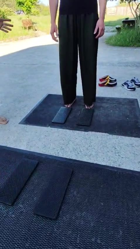 Pieds nus posés sur deux planches à clous pendant une séance de sadhu board