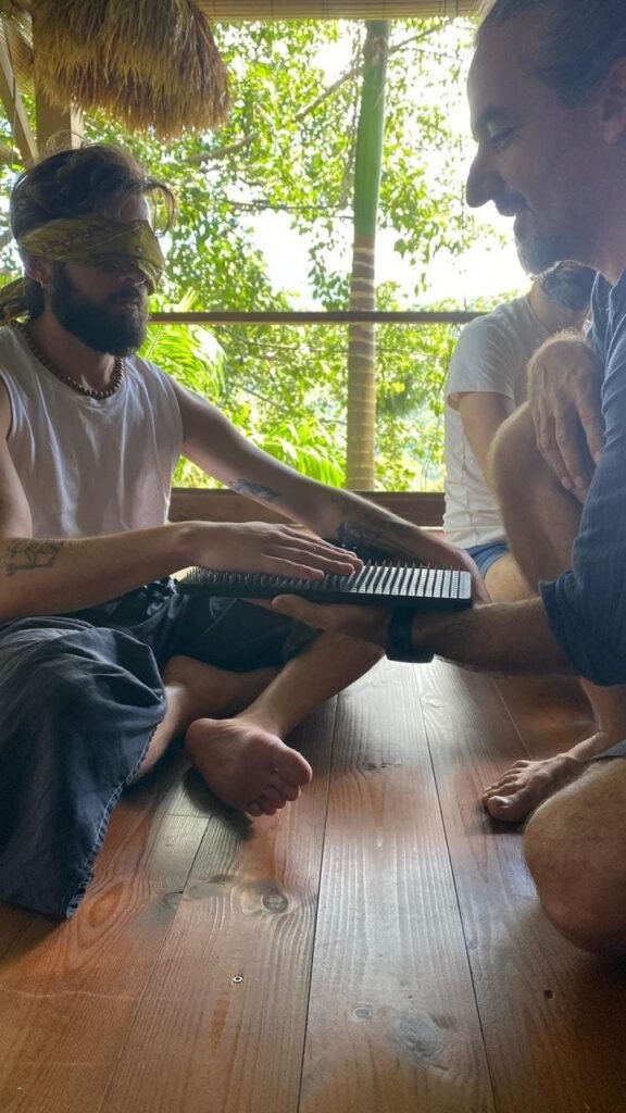 Participant aux yeux bandés, les mains posées sur un sadhu board